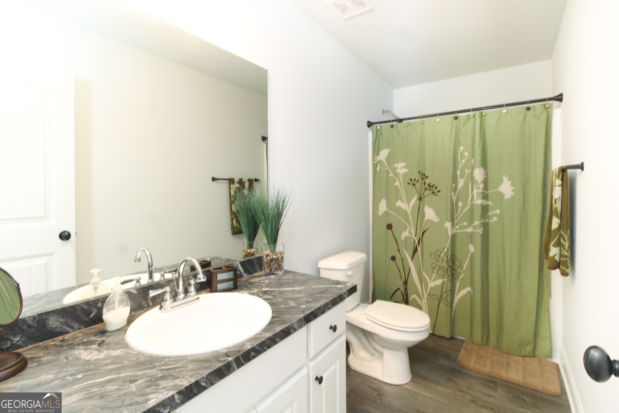 31 Rolling Woods Lane Colbert, GA 30628 - Photo 23 of 30 a bathroom with a granite countertop sink toilet a mirror and shower