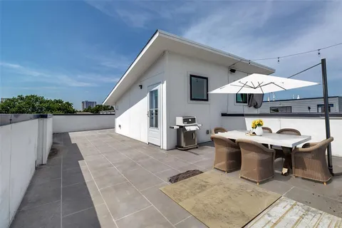 a view of a patio with a dining table and chairs under an umbrella