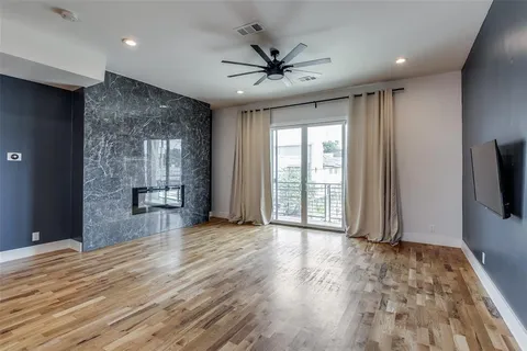 a view of a livingroom with wooden floor and a ceiling fan