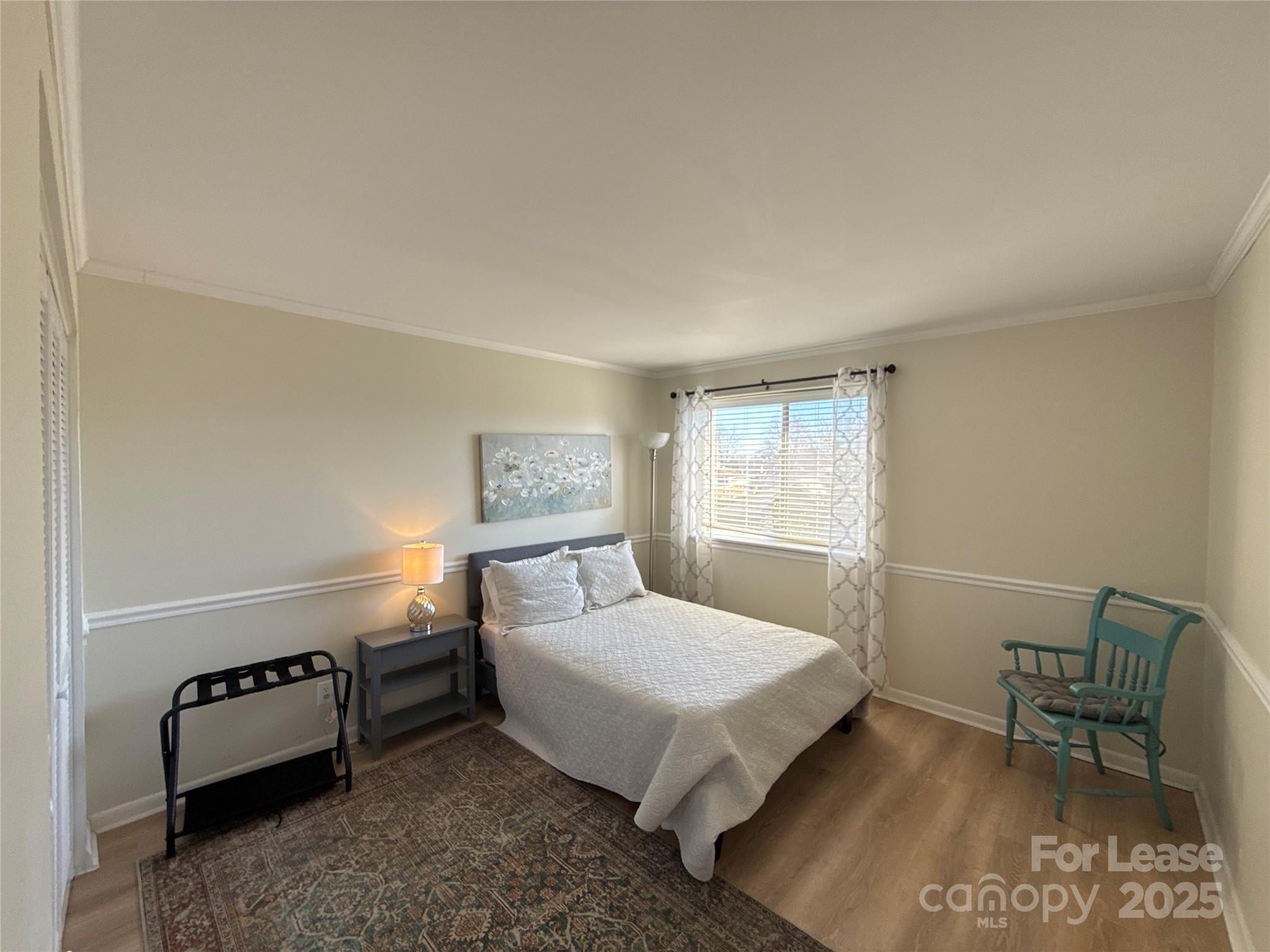 1323 Queens Road, Unit 322 Charlotte, NC 28207 - Photo 11 of 22 a bedroom with a bed a table and chair