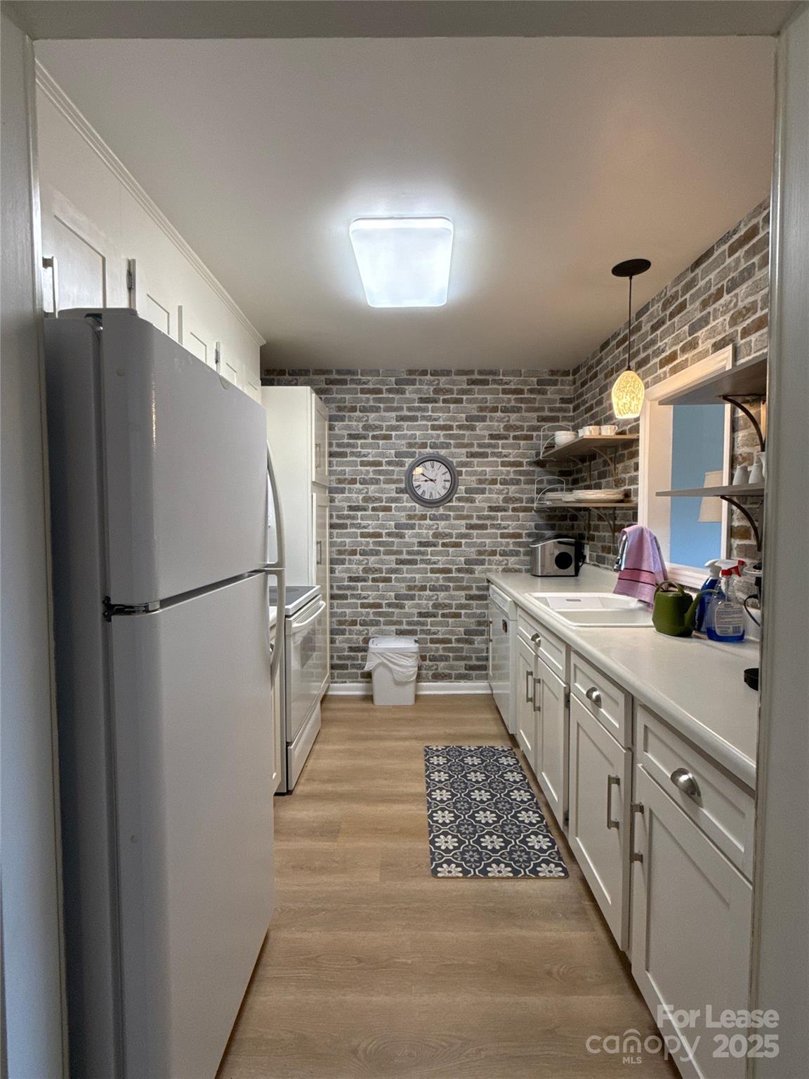 1323 Queens Road, Unit 322 Charlotte, NC 28207 - Photo 4 of 22 a kitchen with sink cabinets and stainless steel appliances