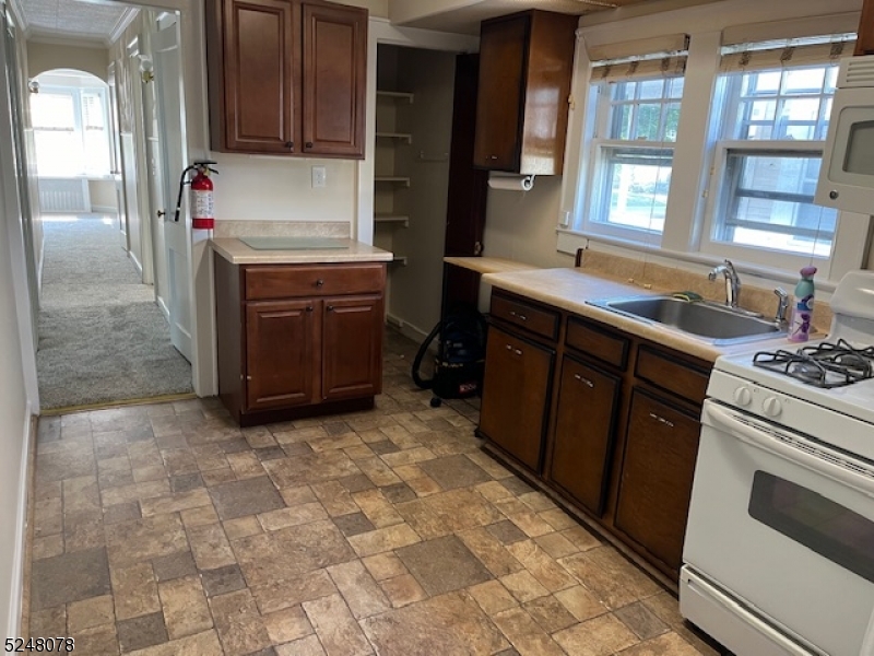 136 East Main Street, Unit 1 Little Falls, NJ 07424 - Photo 5 of 12 a kitchen with a stove sink and cabinets