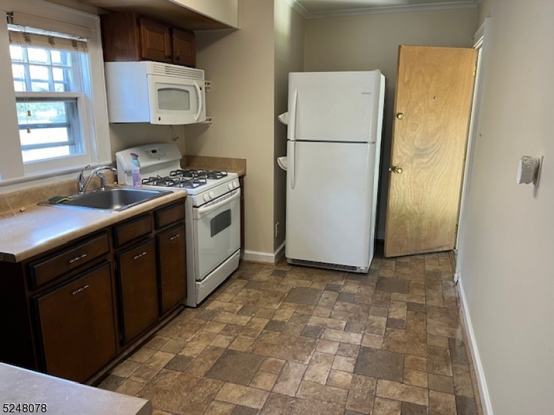 136 East Main Street, Unit 1 Little Falls, NJ 07424 - Photo 6 of 12 a kitchen with a sink a refrigerator and a stove top oven