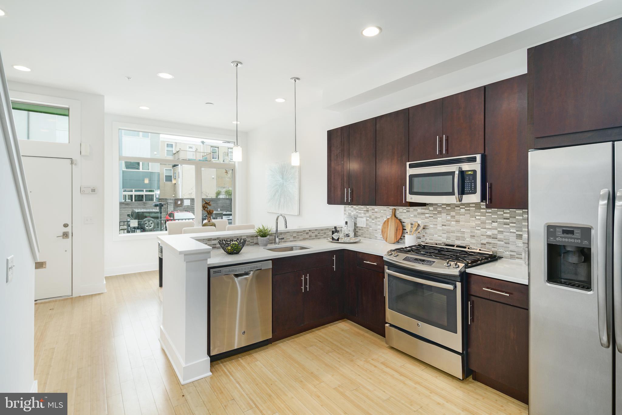 a large kitchen with stainless steel appliances granite countertop a stove and a sink