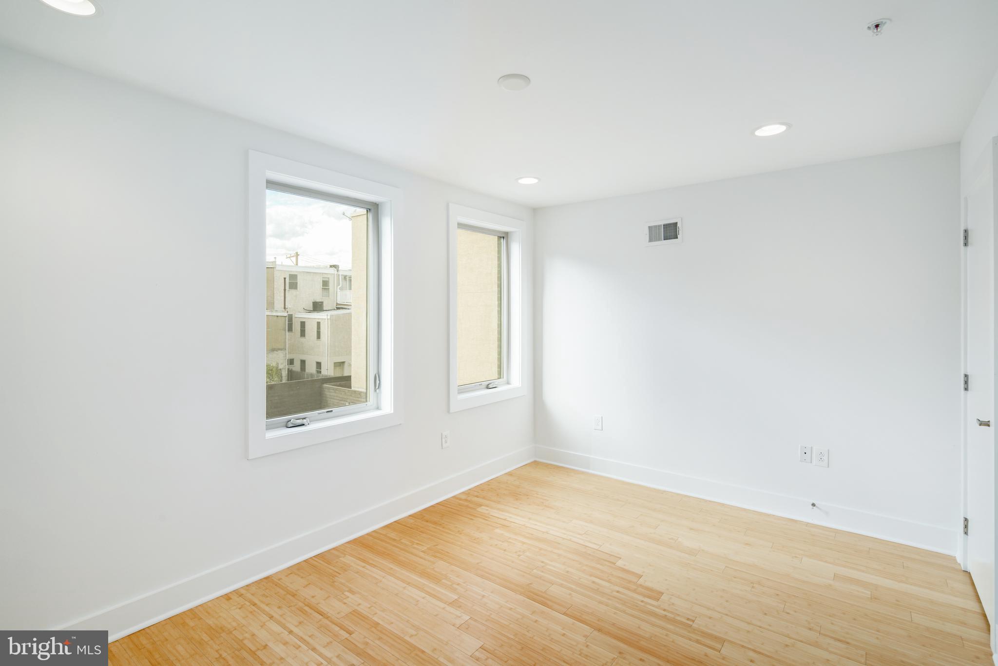 1135 Hope Street, Unit 18 Philadelphia, PA 19123 - Photo 15 of 21 an empty room with wooden floor and windows