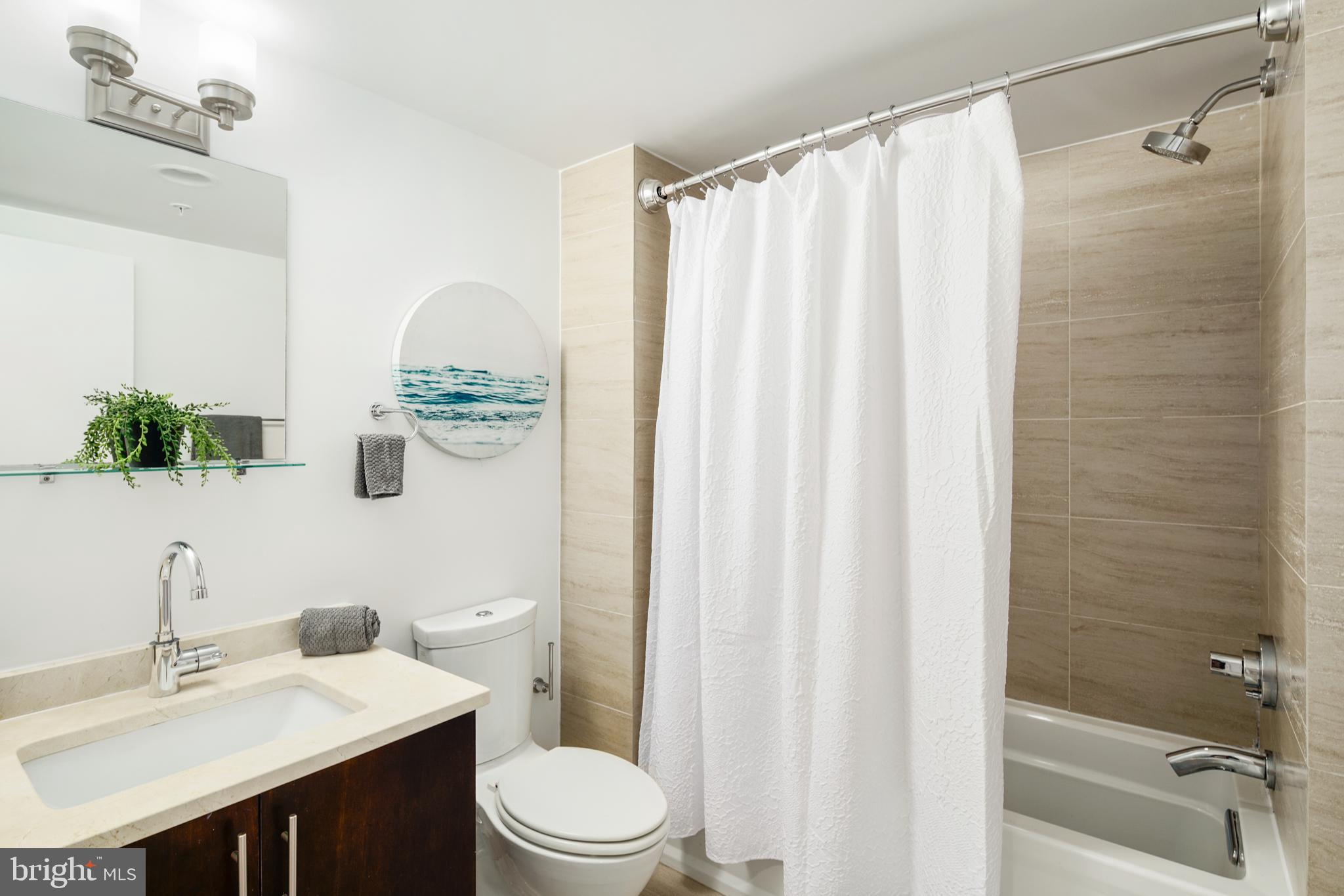 1135 Hope Street, Unit 18 Philadelphia, PA 19123 - Photo 17 of 21 a bathroom with a sink a toilet and shower curtain
