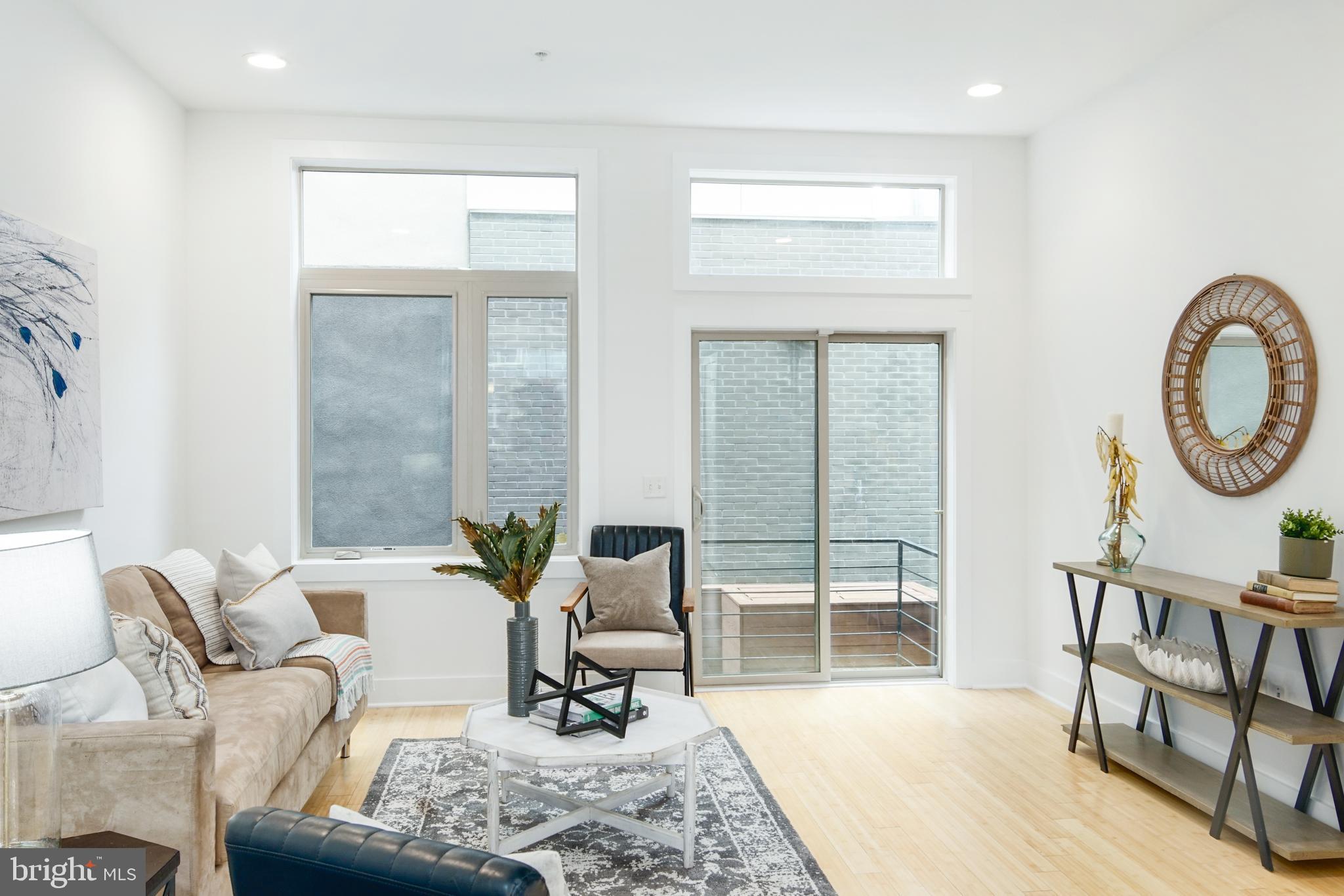 1135 Hope Street, Unit 18 Philadelphia, PA 19123 - Photo 7 of 21 a living room with furniture a rug a lamp and a large window