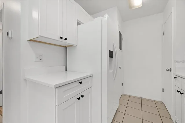 a kitchen with white cabinets and white appliances