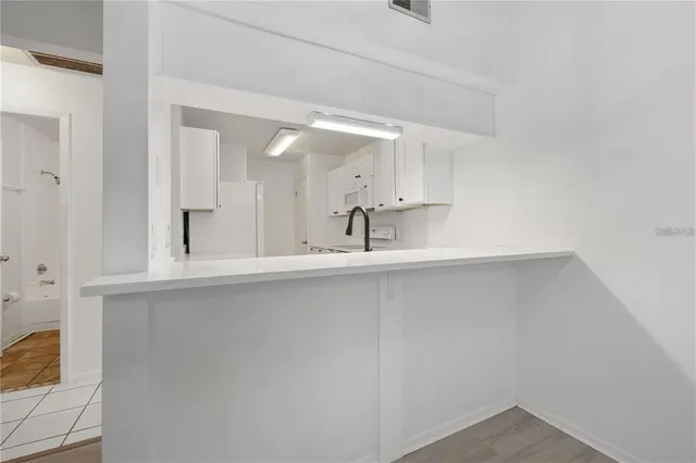 an empty room with wooden floor and a ceiling fan