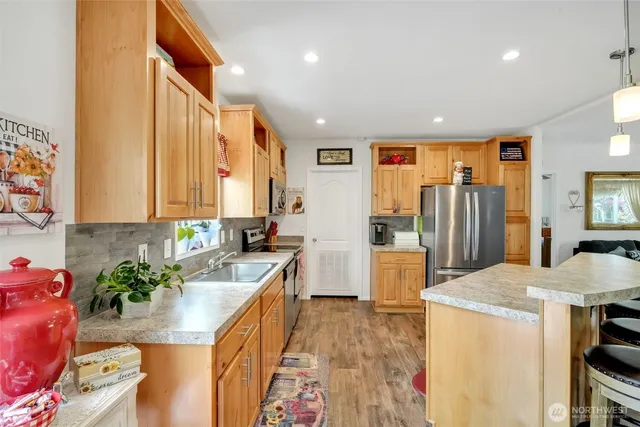 a kitchen with stainless steel appliances granite countertop sink stove refrigerator and cabinets