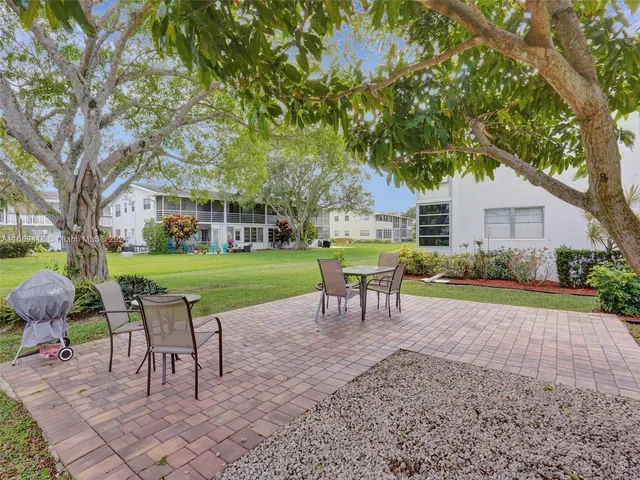 a view of a chairs and table in backyard of the house