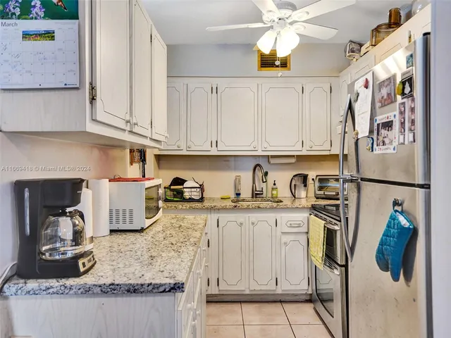a kitchen with stainless steel appliances granite countertop a refrigerator and a stove