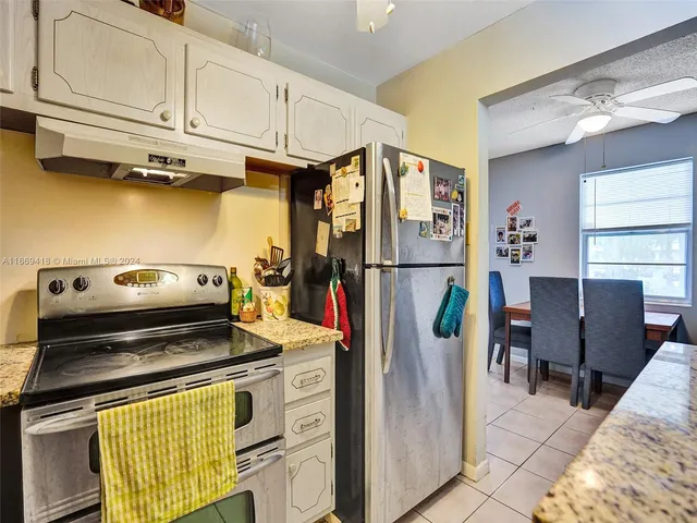 a kitchen with stainless steel appliances granite countertop a refrigerator and a stove