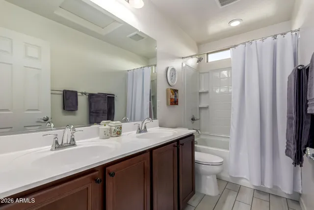 a bathroom with a double vanity sink toilet and shower