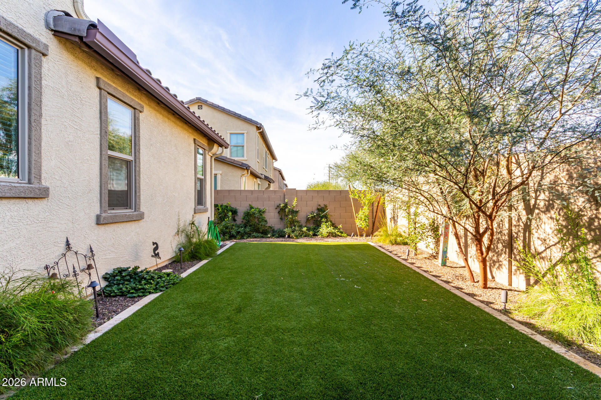5740 West Raymond Street Phoenix, AZ 85043 - Photo 23 of 41 a backyard of a house with plants and large tree