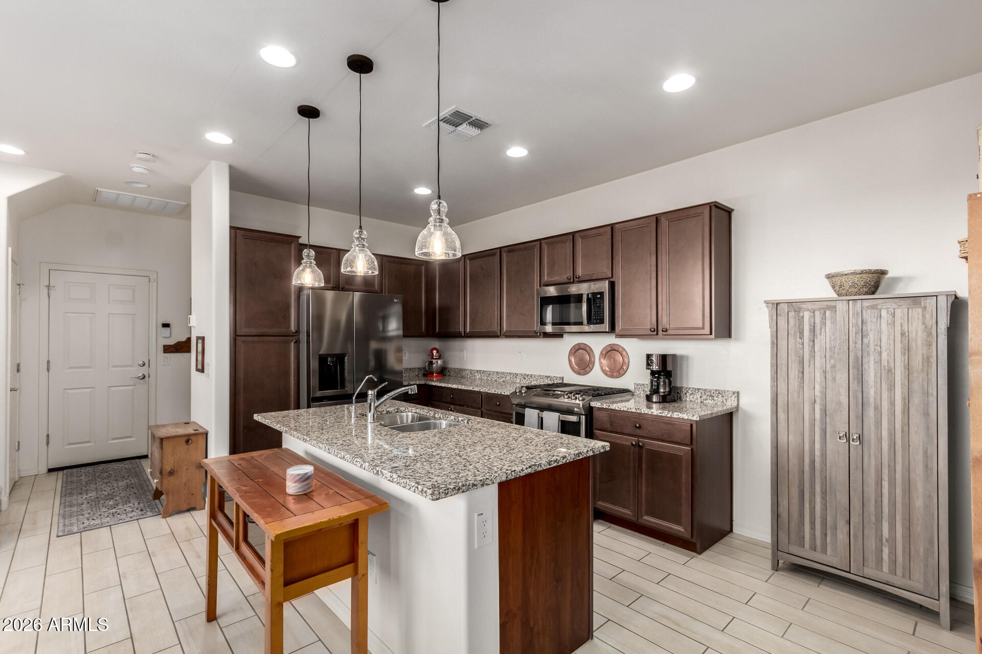 5740 West Raymond Street Phoenix, AZ 85043 - Photo 8 of 41 a kitchen with stainless steel appliances granite countertop a sink a stove a refrigerator and island with wooden floor