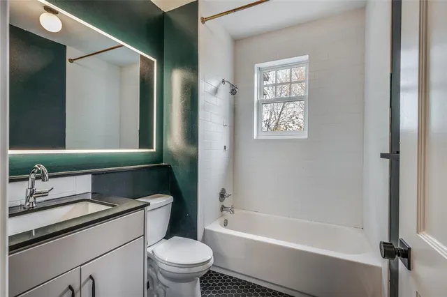 a bathroom with a granite countertop toilet a sink and a bathtub