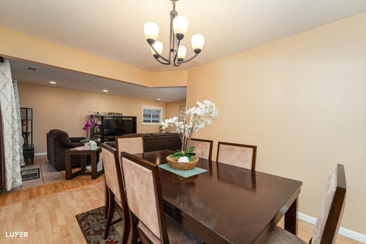 4448 Adele Lane Oak Forest, IL 60452 - Photo 11 of 28 a view of a dining room with furniture a chandelier and wooden floor