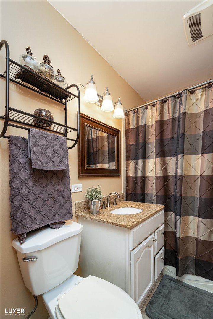 4448 Adele Lane Oak Forest, IL 60452 - Photo 22 of 28 a bathroom with a granite countertop toilet sink and mirror