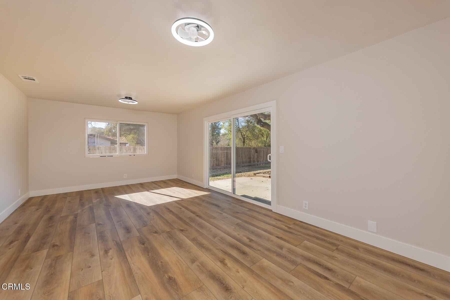 165 Burnham Road Oak View, CA 93022 - Photo 19 of 58 an empty room with wooden floor and windows