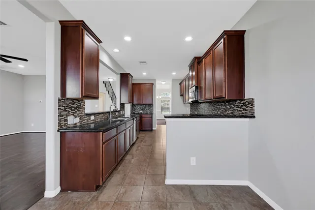 a kitchen with stainless steel appliances granite countertop a refrigerator and a stove top oven