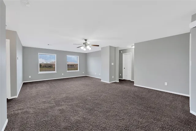an empty room with chandelier and windows
