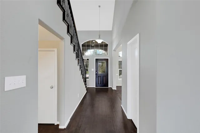 a view of a hallway with wooden floor and staircase
