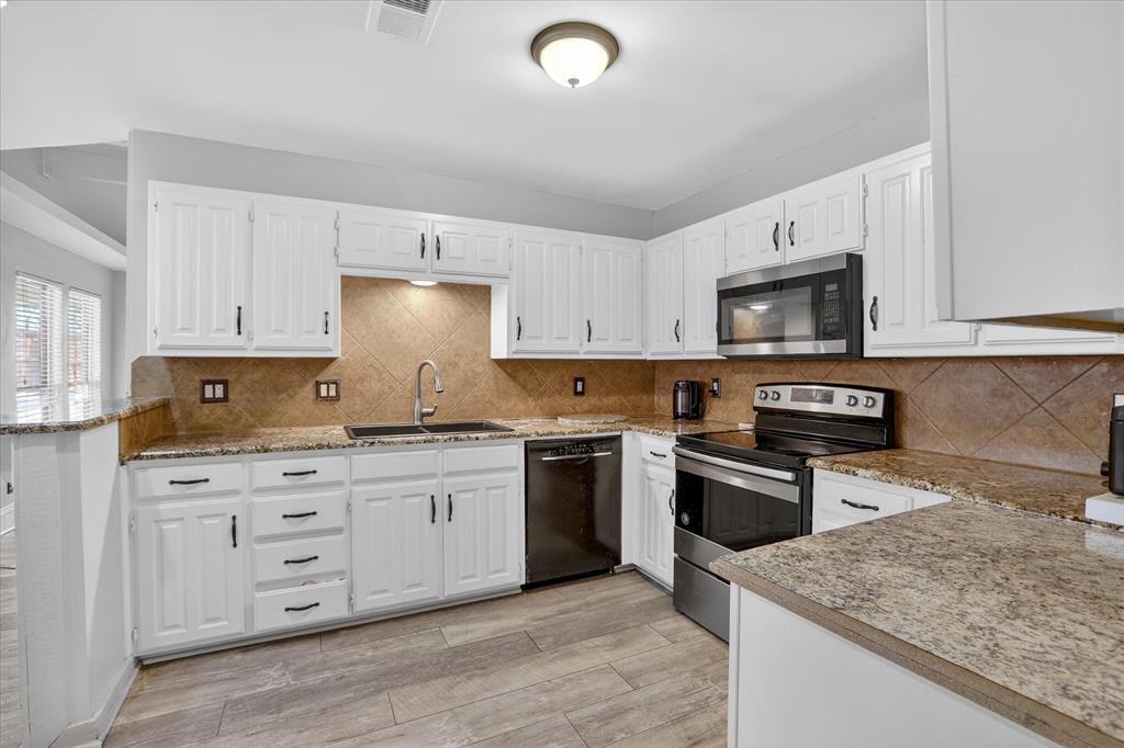 2010 Libby Lane Grand Prairie, TX 75050 - Photo 11 of 24 a kitchen with stainless steel appliances granite countertop a stove sink and cabinets