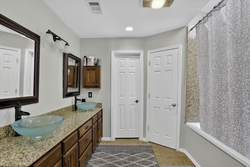 2010 Libby Lane Grand Prairie, TX 75050 - Photo 18 of 24 a bathroom with a granite countertop sink and a mirror