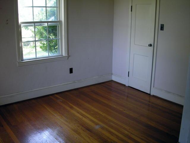 8357 Snow Creek Road Penhook, VA 24137 - Photo 8 of 8 a view of an empty room with wooden floor and a window