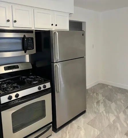 a kitchen with stainless steel appliances a refrigerator stove and cabinets