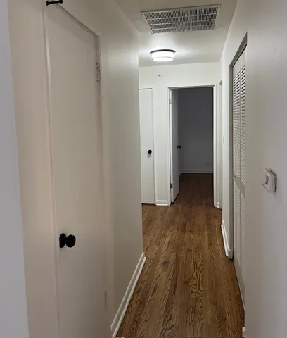 a view of a hallway with wooden floor