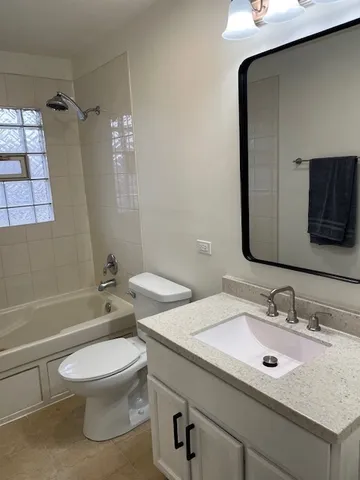 a bathroom with a granite countertop toilet sink and mirror