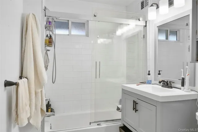 a bathroom with a sink a mirror a shower and a mirror