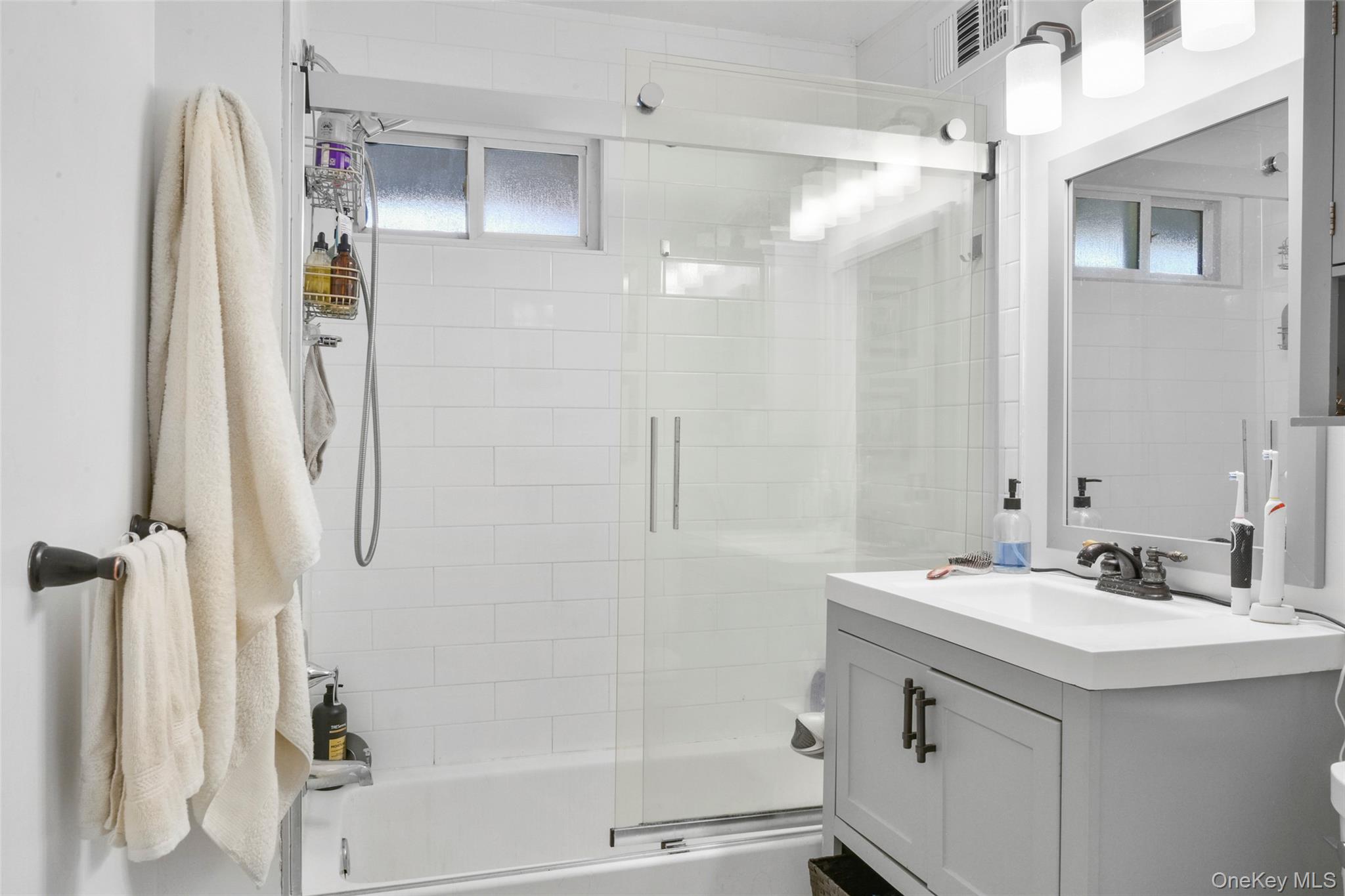 330 First Avenue, Unit LEFT SIDE Pelham, NY 10803 - Photo 13 of 19 a bathroom with a sink a mirror a shower and a mirror