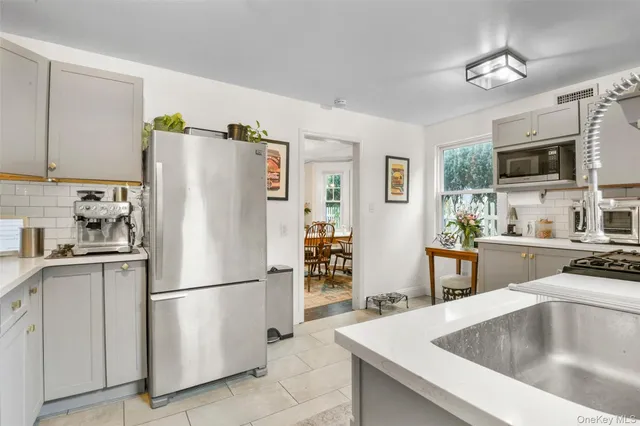 a kitchen with stainless steel appliances a refrigerator sink and microwave
