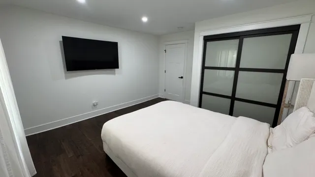 a bedroom with a bed and a flat screen tv