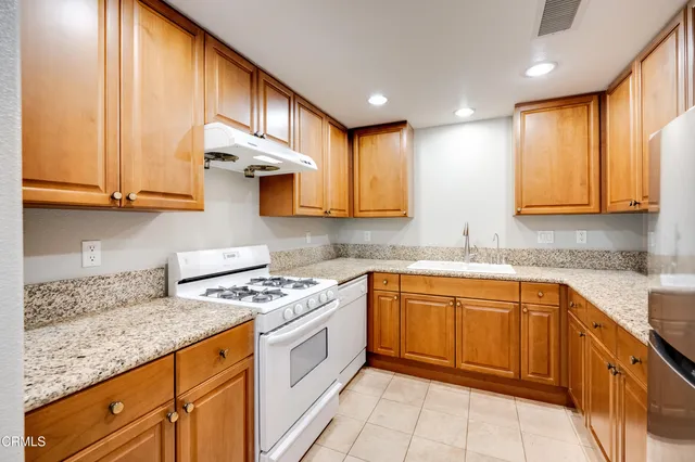 a kitchen with stainless steel appliances granite countertop a sink stove and cabinets