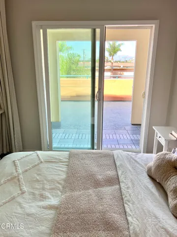 a bedroom with a bed and a large window