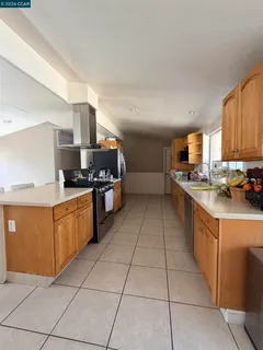 a kitchen with stainless steel appliances granite countertop a sink counter space cabinets and a view of living room