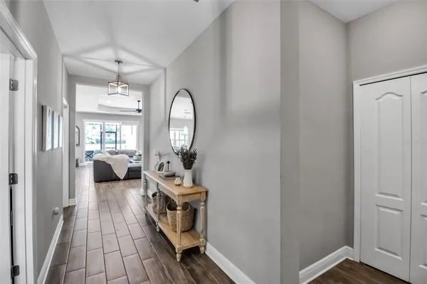 a living room with furniture kitchen view and a chandelier