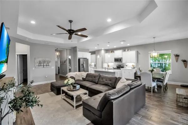 a large kitchen with a counter space a sink appliances and living room view