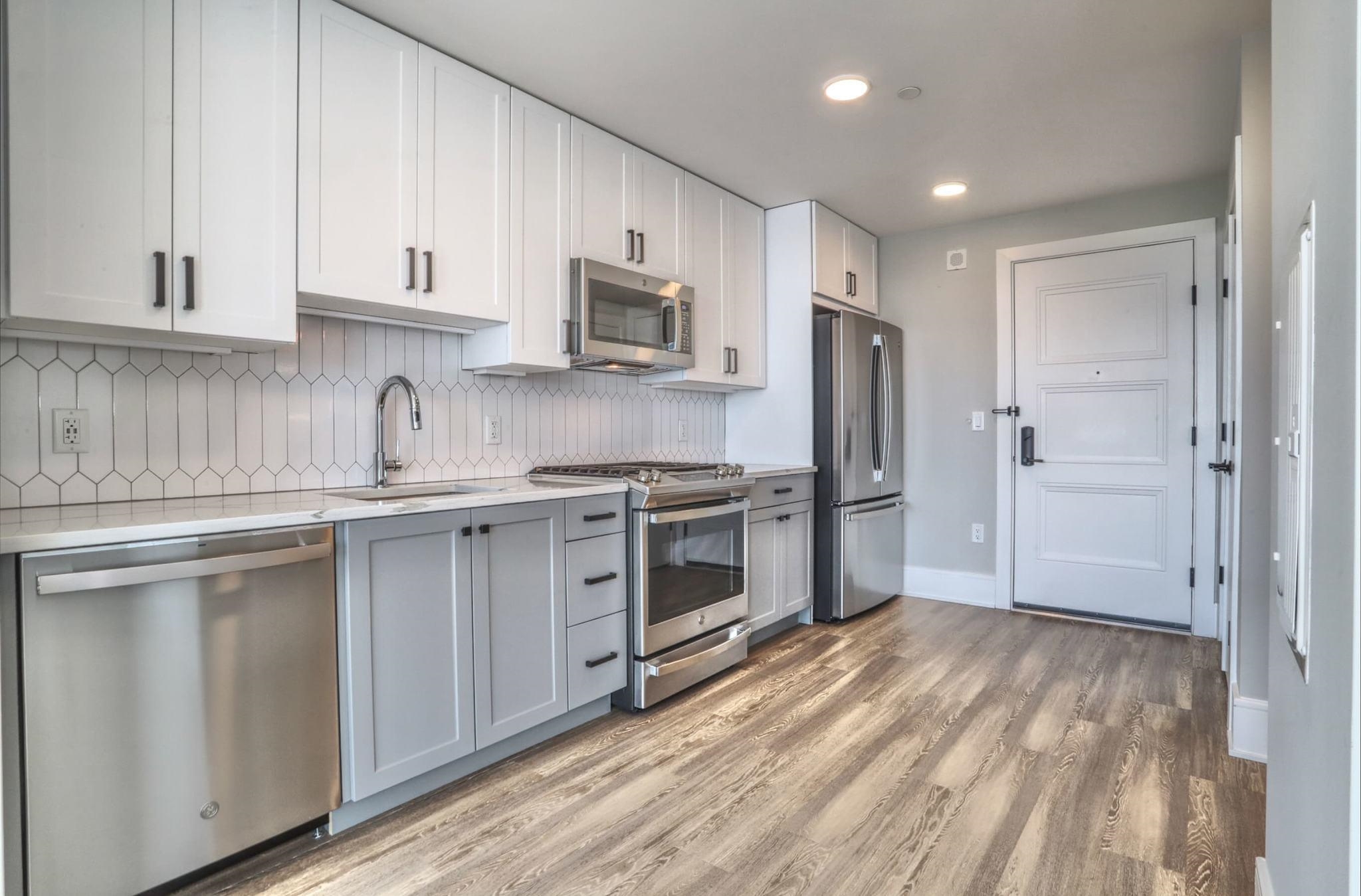 a kitchen with stainless steel appliances granite countertop a refrigerator and a stove top oven