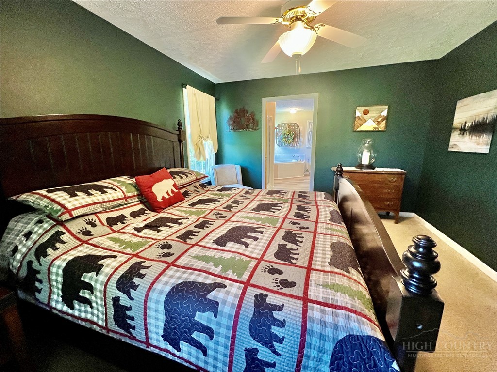 139 New River Ridge Estates Laurel Springs, NC 28644 - Photo 12 of 34 a bedroom with a bed and a chandelier