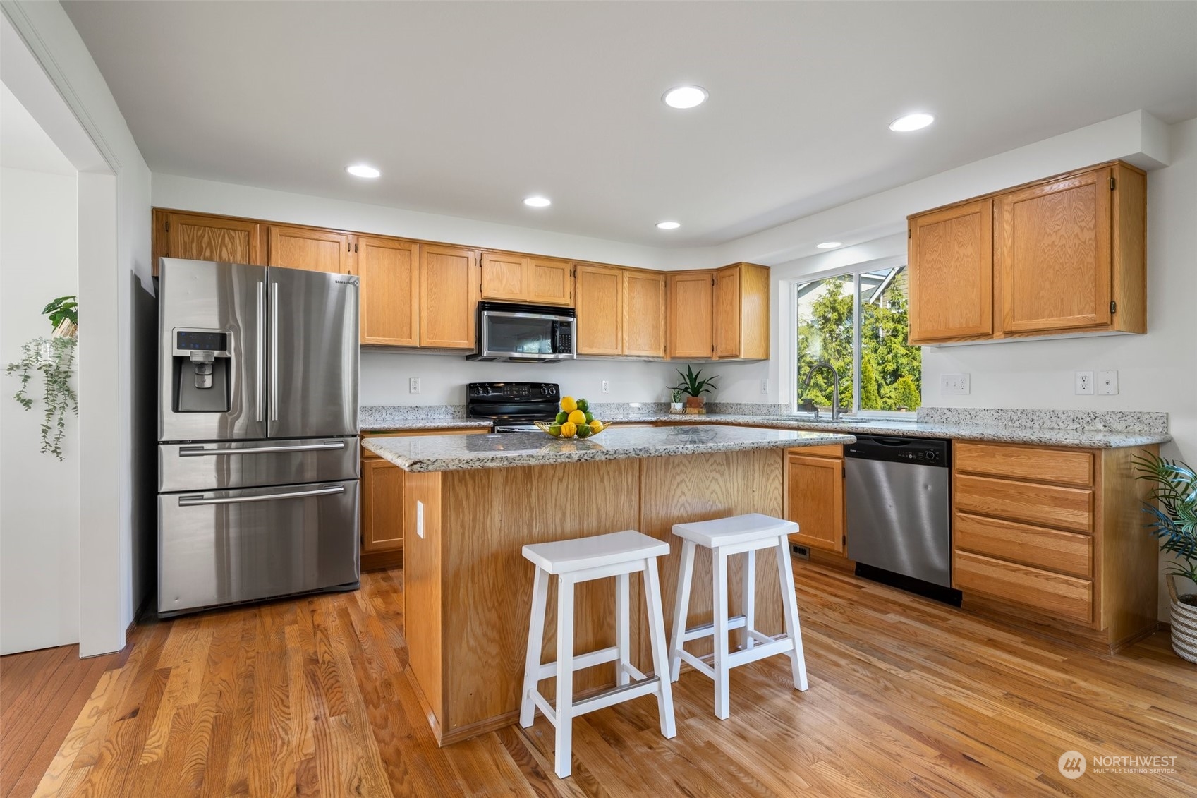 4318 Northeast 2nd Court Renton, WA 98059 - Photo 6 of 29 a kitchen with granite countertop a refrigerator and a stove top oven