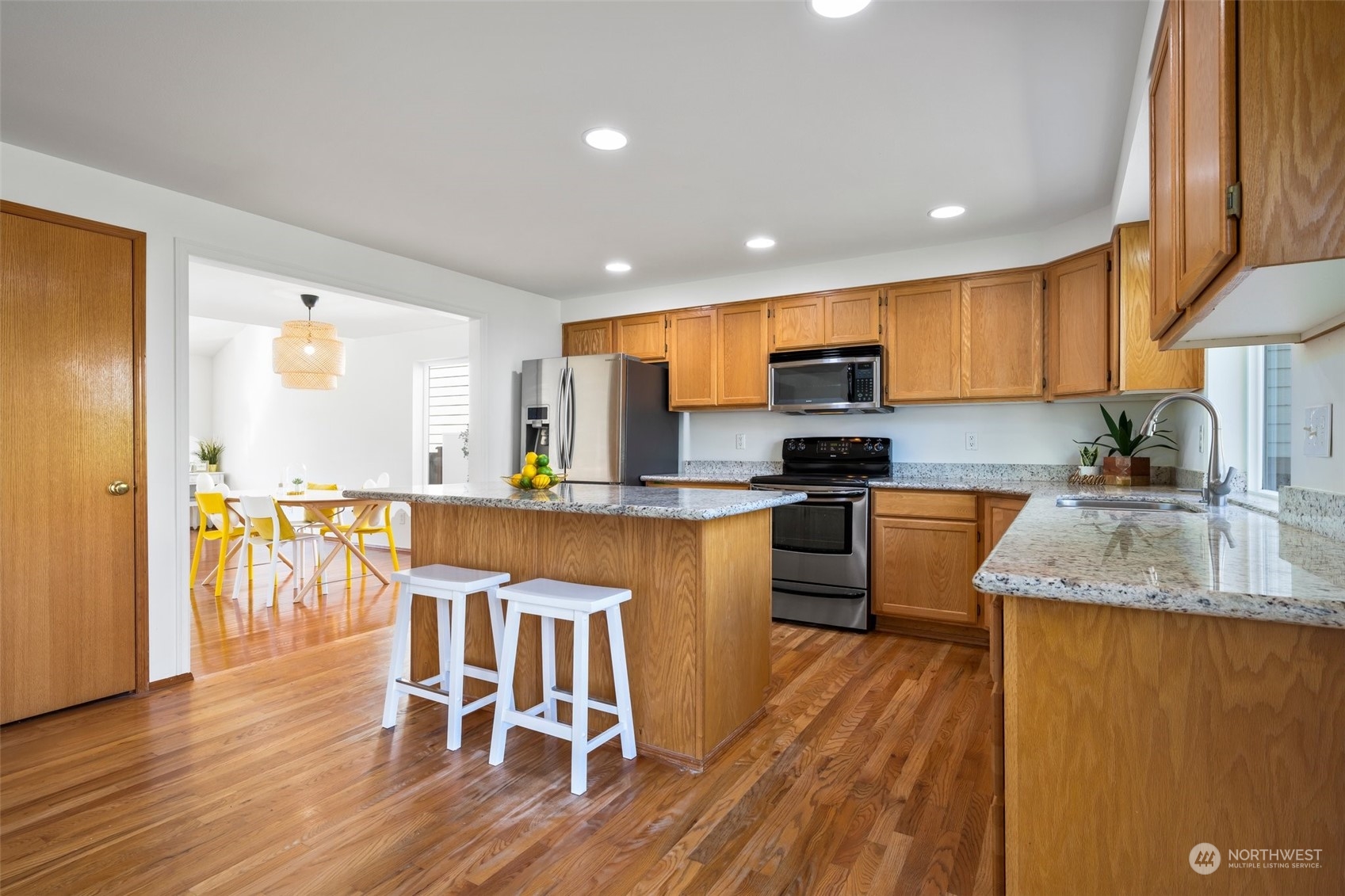 4318 Northeast 2nd Court Renton, WA 98059 - Photo 7 of 29 a kitchen with stainless steel appliances granite countertop wooden floors a stove top oven a granite counter tops and a view of living room