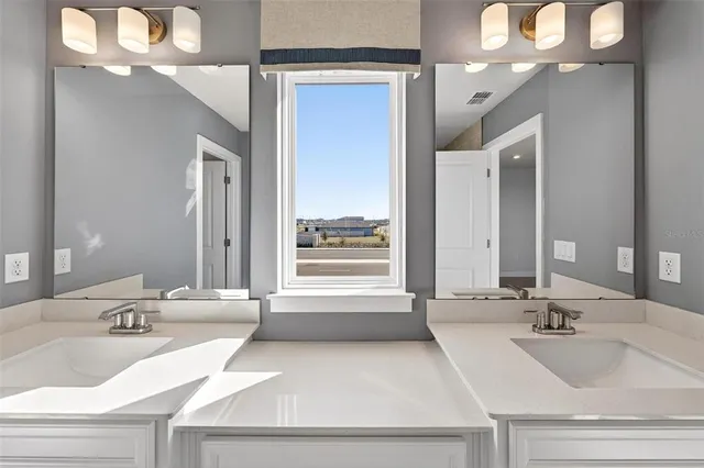 a bathroom with a double vanity sink toilet mirror and shower