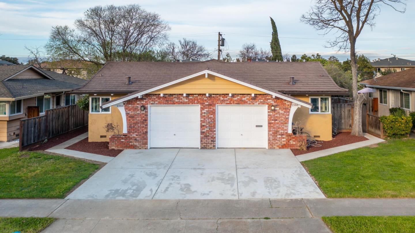 a view of a house with a backyard and a tree