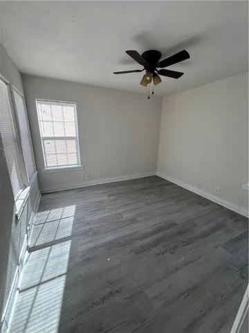 an empty room with windows and fan