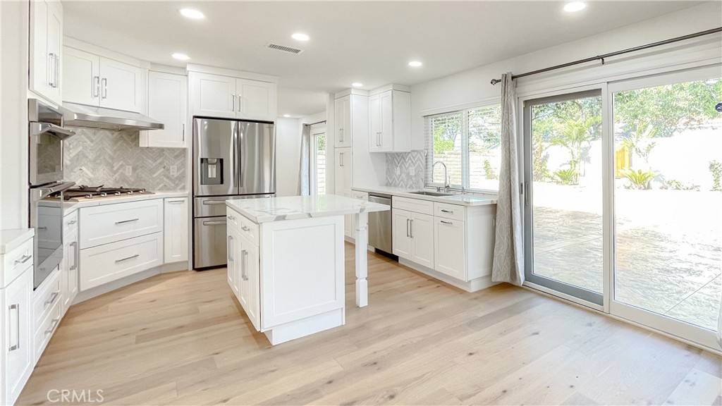 45 Westport Irvine, CA 92620 - Photo 9 of 45 a kitchen with white cabinets and white appliances